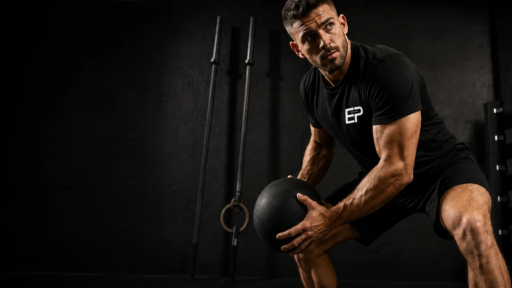 Elouan, coach sportif, en appui sur un medicine ball dans une salle de sport